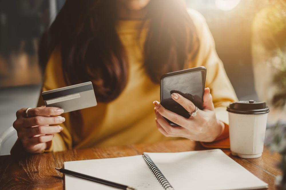 woman using smart phone and credit card for shopping online in coffee shop