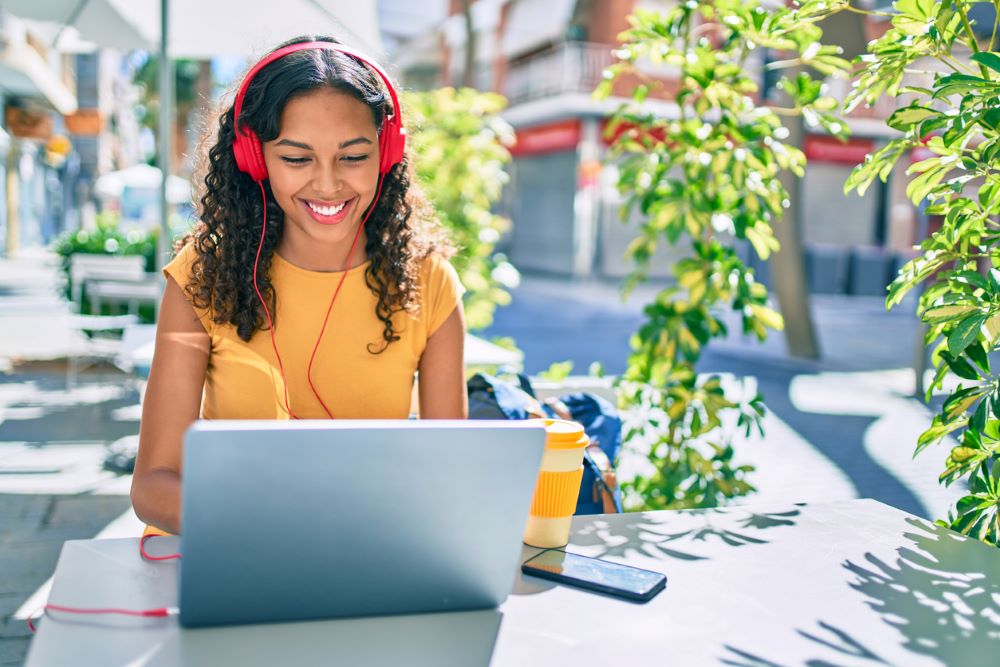 college student sitting outside using her laptop