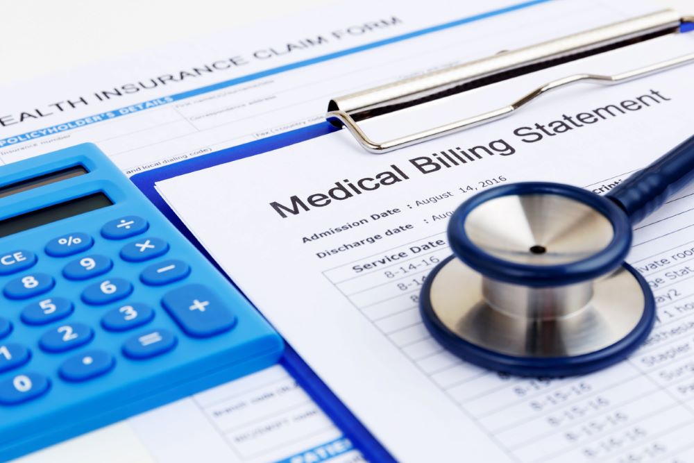 A blue calculator next to a medical billing statement.