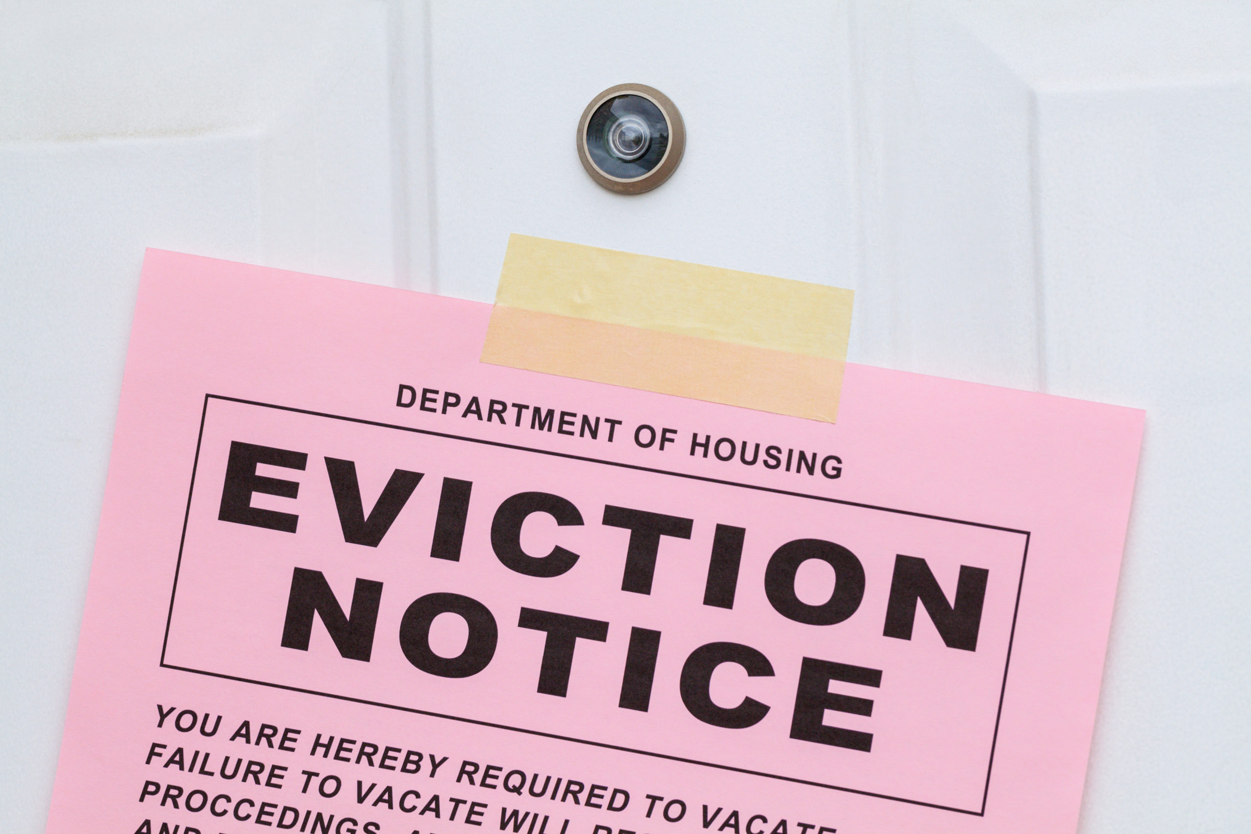 Pink eviction notice on white door.