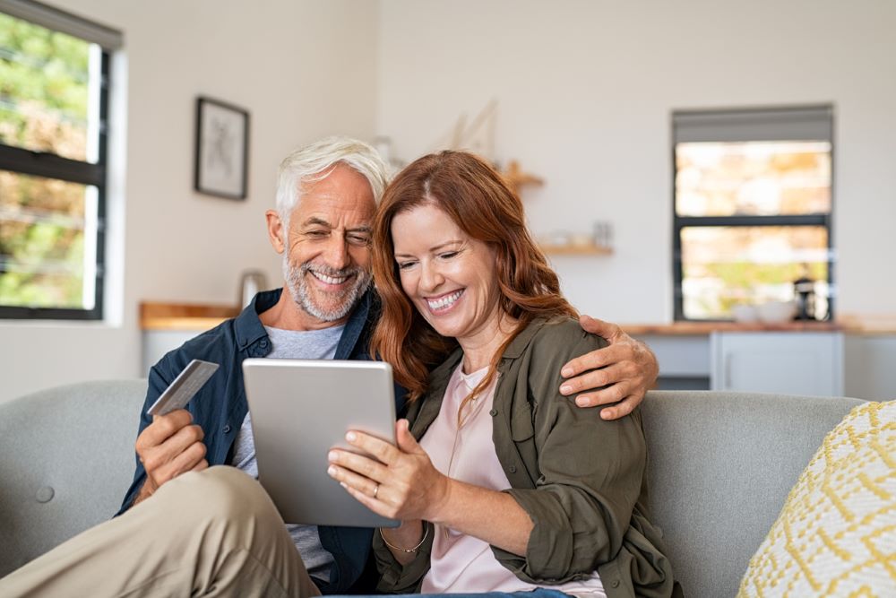 Mature couple doing online shopping with digital table.