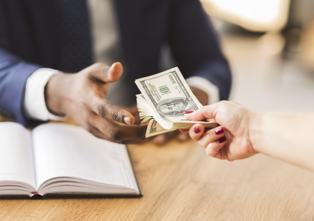 A businessman taking money from a person.