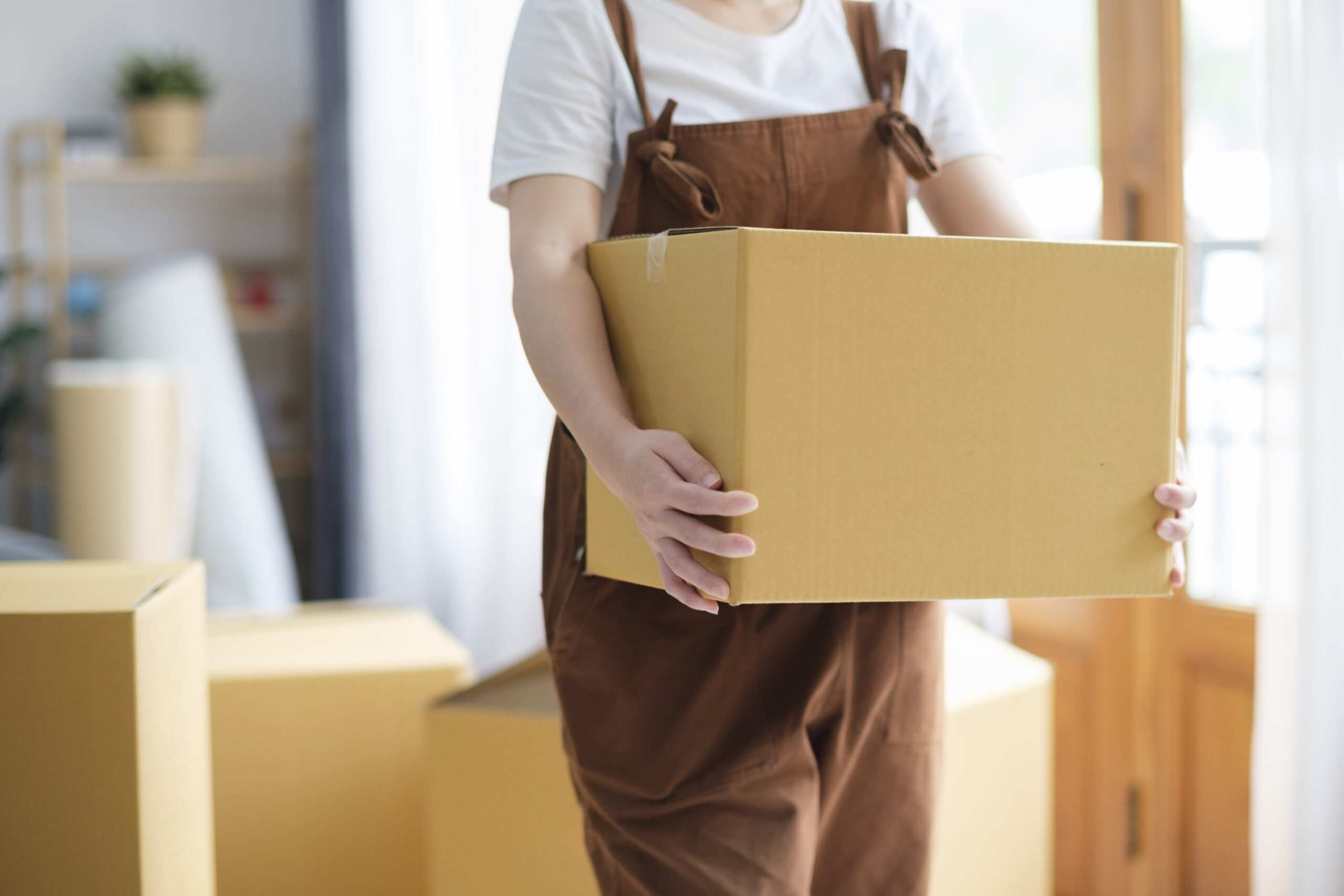 Woman holding box moving into new home.