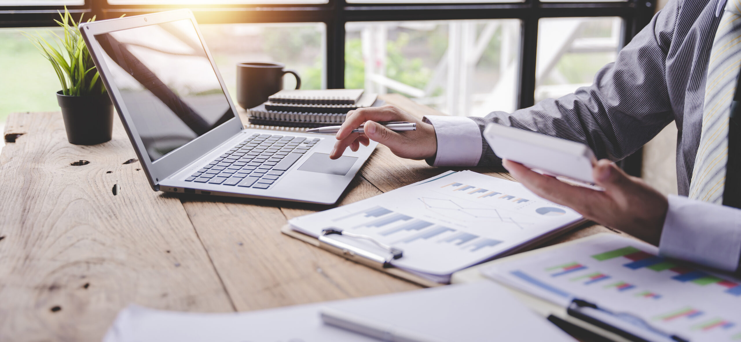 ortrait of a businessman working on a tablet computer in a modern office. Make an account analysis report. real estate investment information financial and tax system concepts