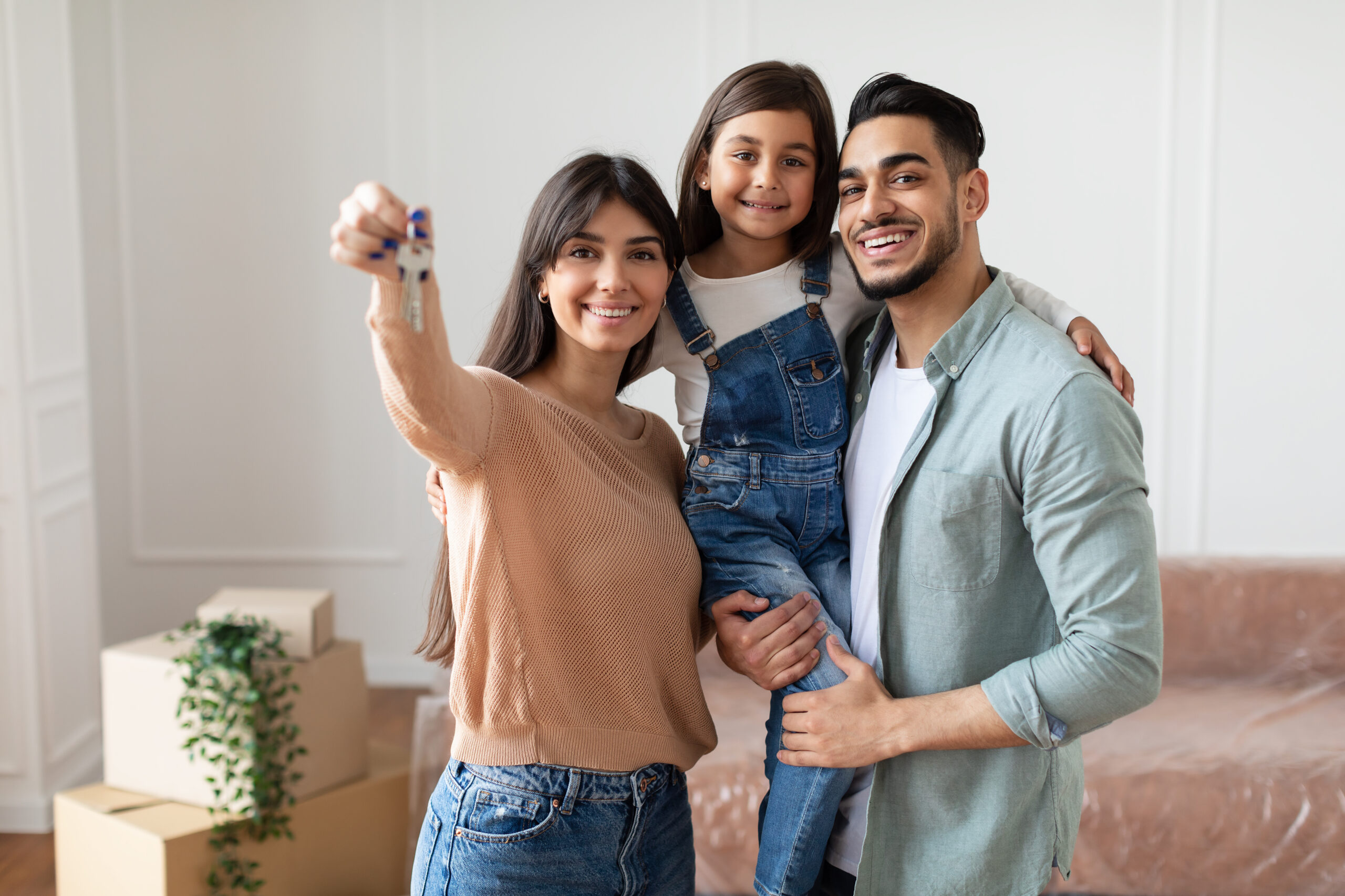 Portrait Of Happy Young Family Showing Key