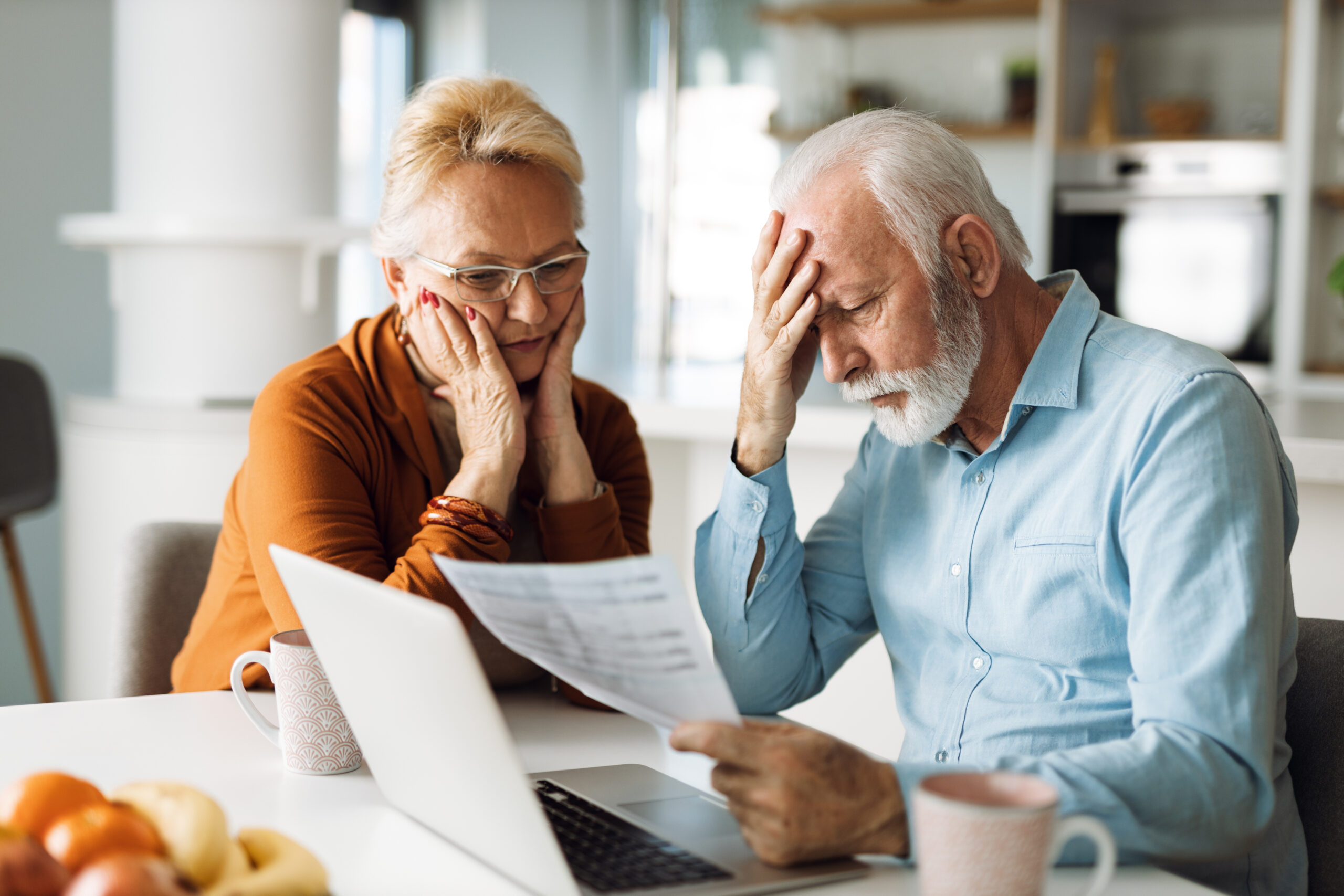 Frustrated mature couple looking at piece of paper.