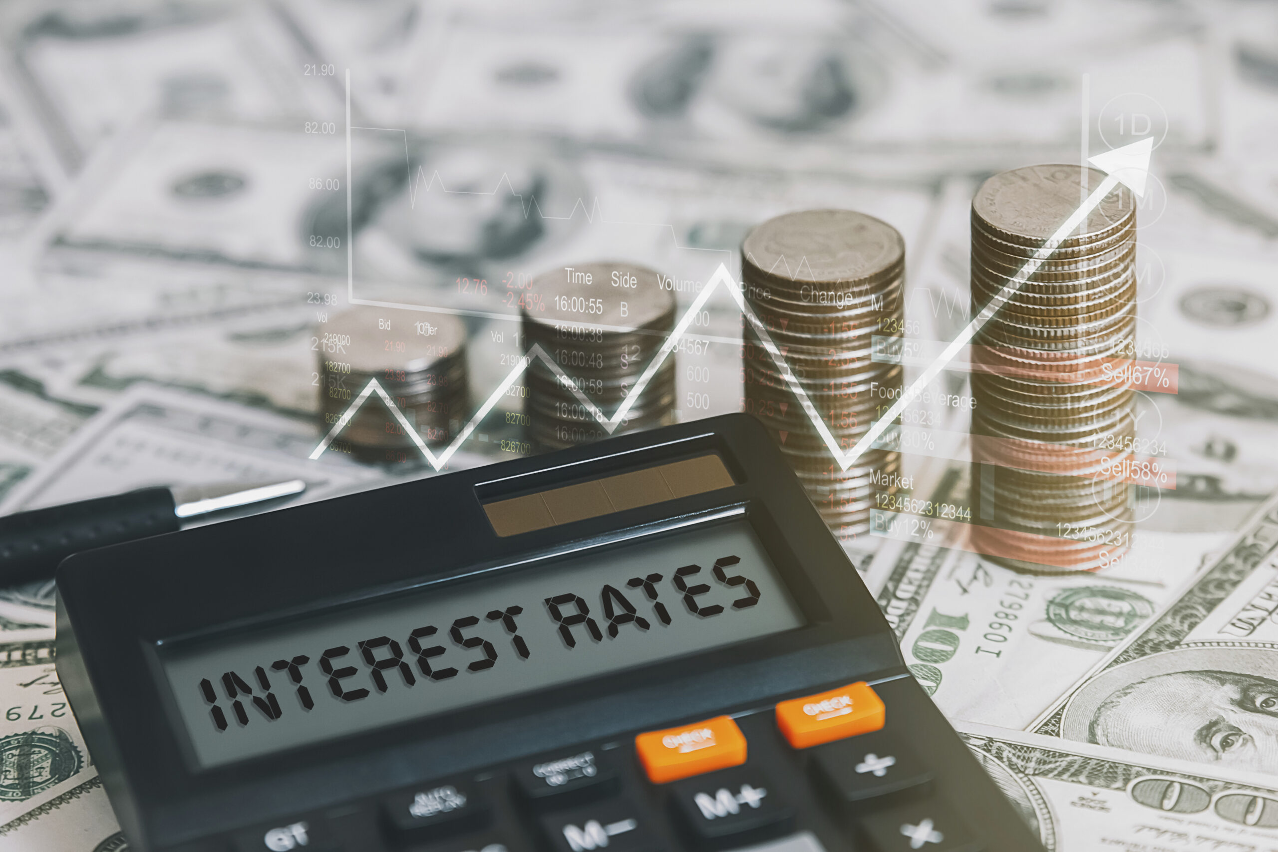 The word interest rate is on a calculator with a coin, a graph, and an arrow pointing up.