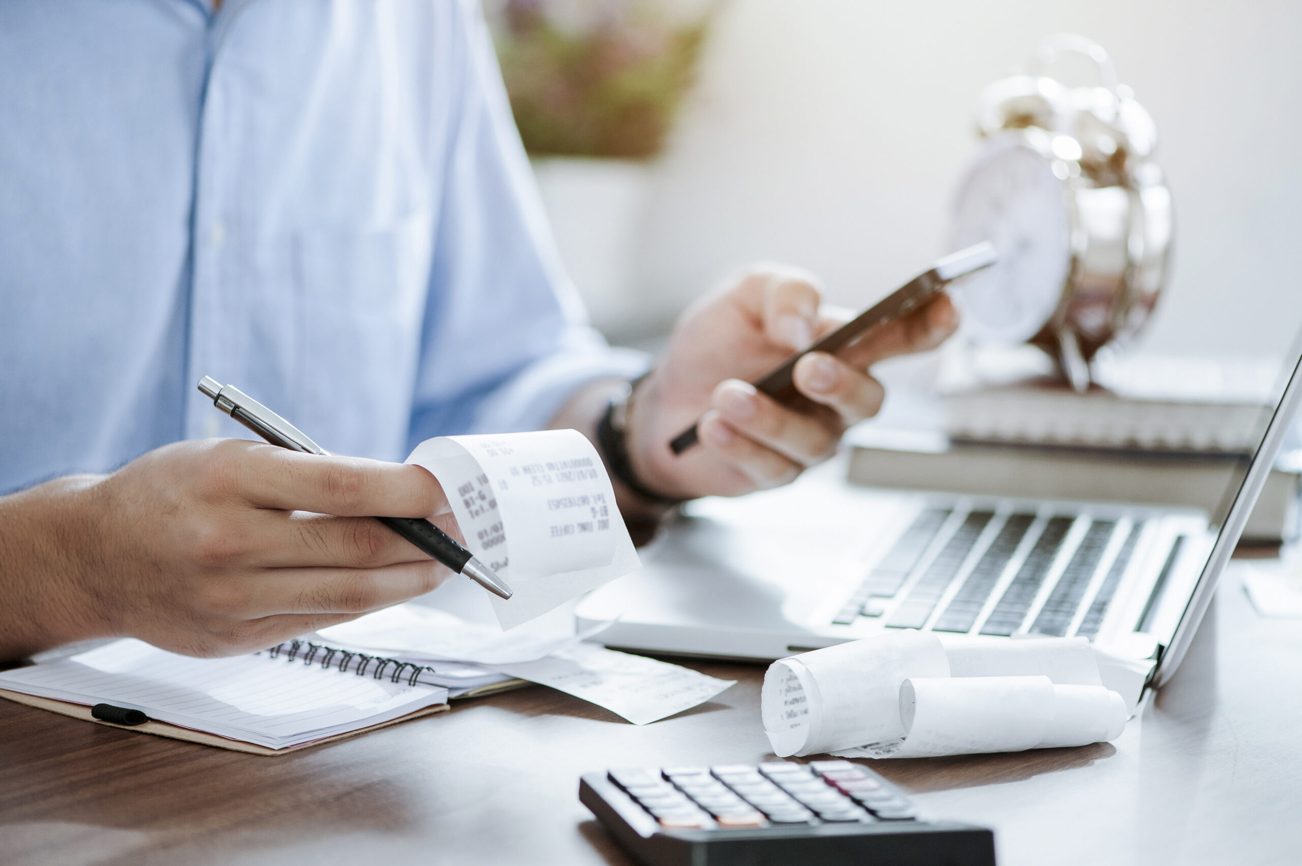 man holding pen calculating tax bills